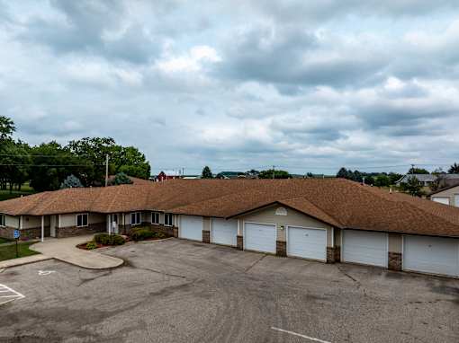 A parking lot in front of a building with a brown roof.