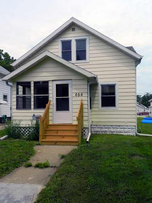 A house with a white door and windows with the number 656 on the window.