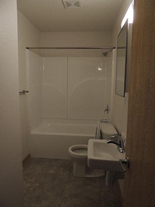 A white toilet and sink in a small bathroom.