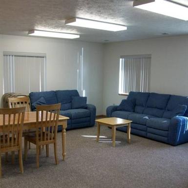 A community room with blue couches and wooden furniture.
