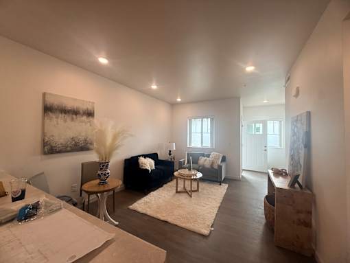 A living room with a couch, a coffee table, and a painting on the wall.