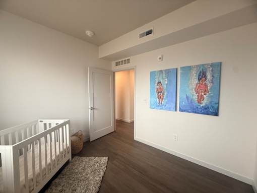 A baby's room with a white crib and two paintings on the wall.