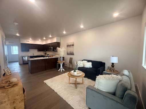 A living room with a grey couch and a wooden coffee table.