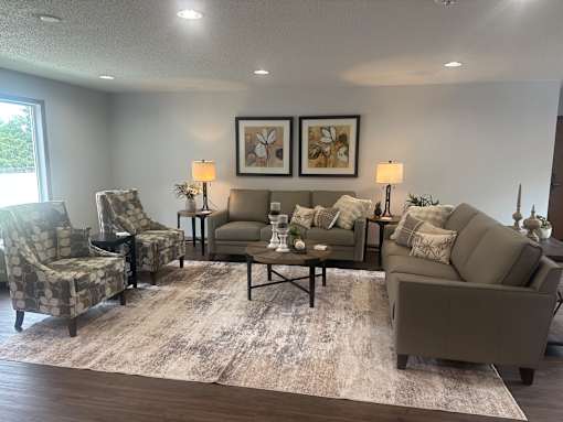 A living room with a grey sofa, two chairs, and a coffee table.