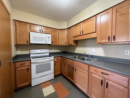 a kitchen with wood cabinets and white appliances