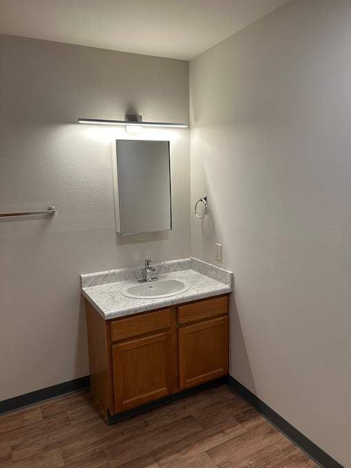 A bathroom with a mirror and a cabinet.