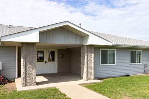 A house with a grey siding and a white roof.
