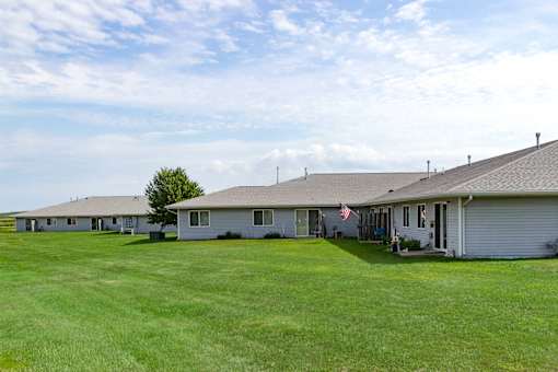 A row of houses with a tree in the distance.