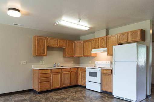 A kitchen with wooden cabinets and a white refrigerator.