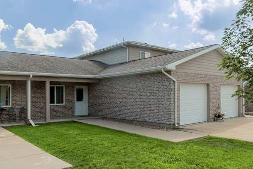 A house with a grey roof and a white garage door.