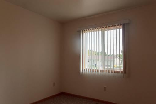 A room with a window covered by a blind.