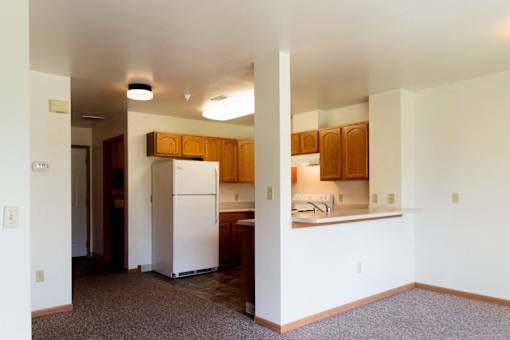 A kitchen with white appliances and wooden cabinets.