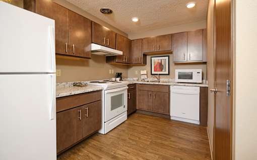 a kitchen with brown cabinets and white appliances