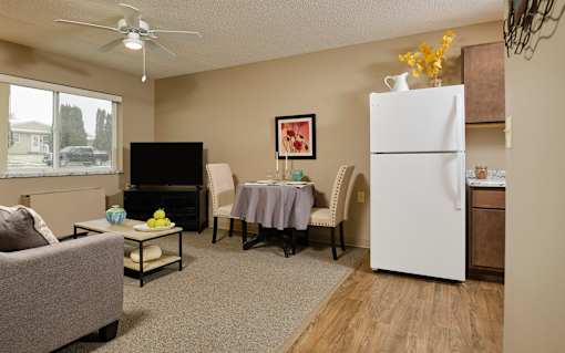 our apartments offer a living room with a couch a dining table and a refrigerator