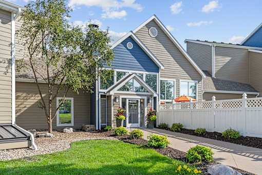 A house with a blue trim and a white picket fence.