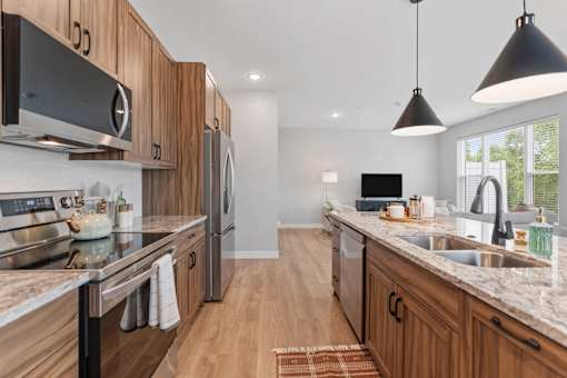 A modern kitchen with wooden cabinets and granite countertops. at Townhomes at Preserve, Rogers, MN, 55374