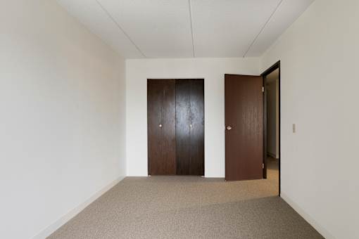 A hallway with two doors and carpeted flooring.
