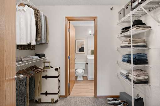 Walk through closet to an ensuite bathroom in a newly renovated apartment home at Park Pointe Apartments in St. Louis Park, MN 55426
