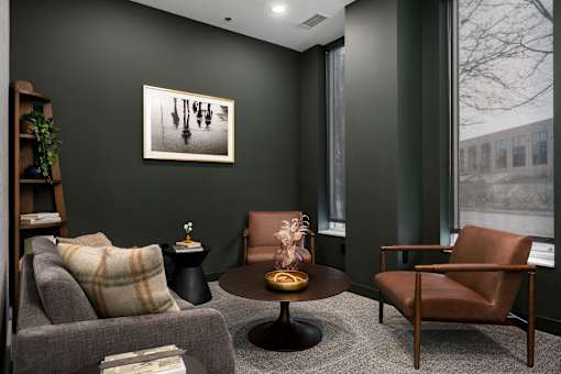 A living room with a grey couch, a brown chair, and a coffee table.