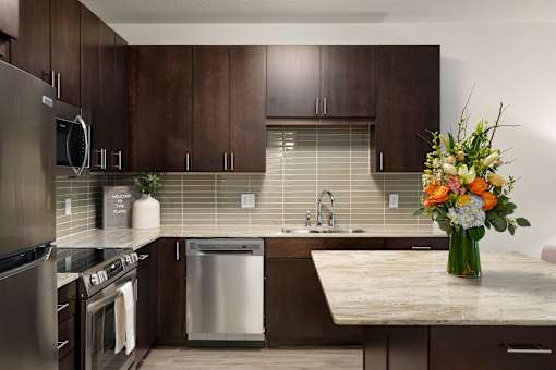 A kitchen with a stainless steel refrigerator, a dishwasher, and a sink.