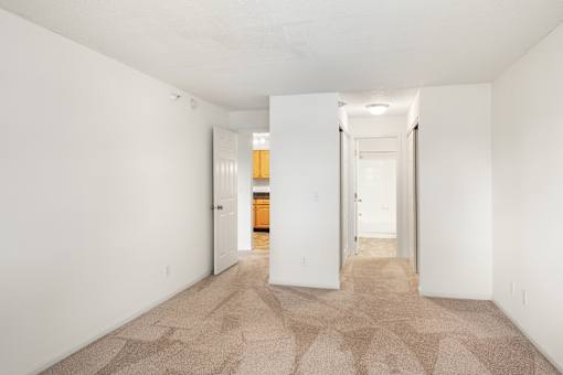 a spacious living room with white walls and a carpeted floor at Cityscape, St Louis Park, 55416