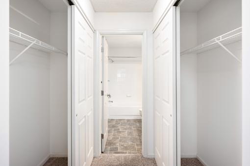 a closet in a bedroom with white doors at Cityscape, St Louis Park, MN, 55416
