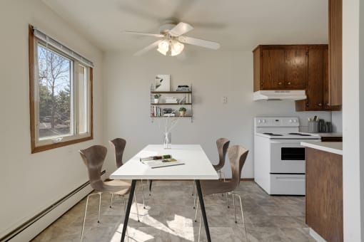 a kitchen with white appliances and a white dining table with four chairs at Hamline Terrace, Roseville, MN, 55113