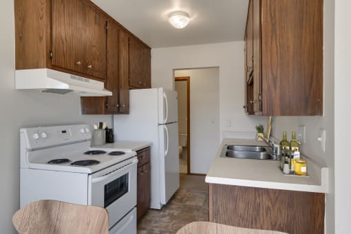 a kitchen with white appliances and wooden cabinets at Hamline Terrace, Roseville, MN, 55113