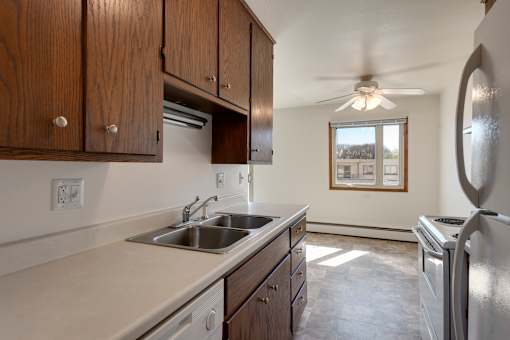 A kitchen with wooden cabinets and a stainless steel refrigerator.