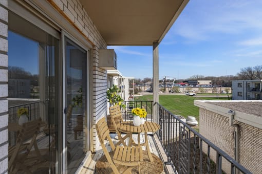 a balcony with a table and chairs and a view of a grassy area at Hamline Terrace, Minnesota, 55113
