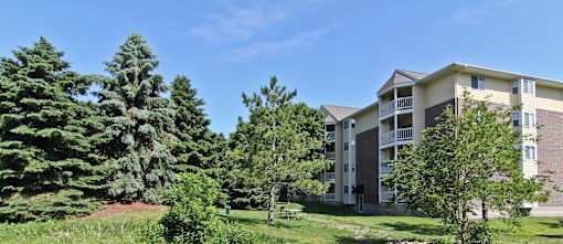 an apartment building on a hill with trees at Cityscape, St Louis Park, MN, 55416