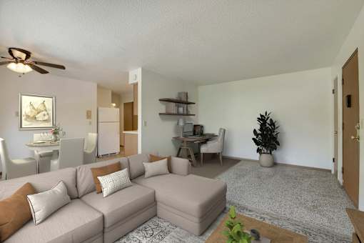 A living room with a grey couch, a coffee table, and a ceiling fan.