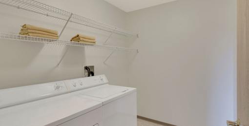 A white washing machine with towels hanging on the rack.