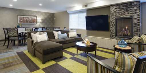 A living room with a brown couch and a stone wall.