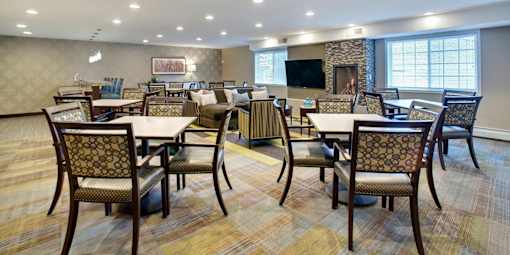 A conference room with a stone fireplace and a television.