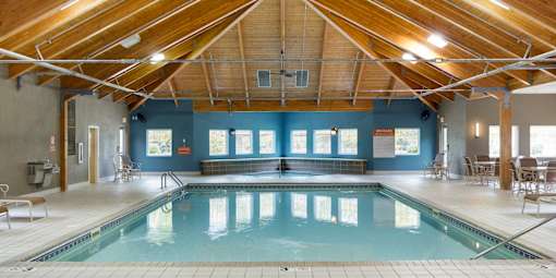 A large indoor swimming pool with a wooden ceiling.
