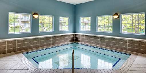 A large indoor swimming pool with a tiled floor and walls.