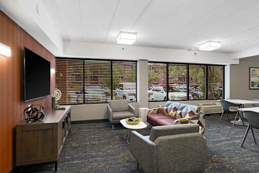 A modern waiting room with a flat screen TV and comfortable seating.