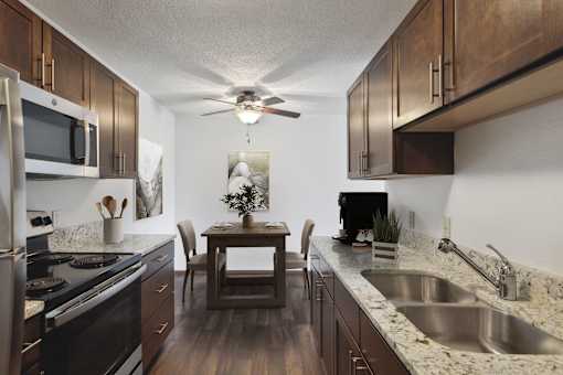 A kitchen with a table and chairs in the middle.