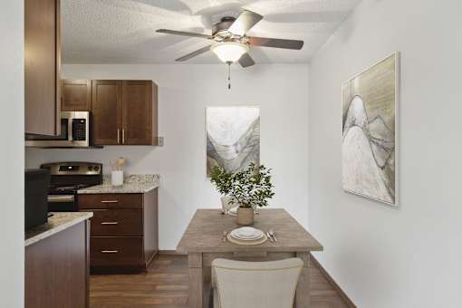 A kitchen with a table and chairs and a plant on it.