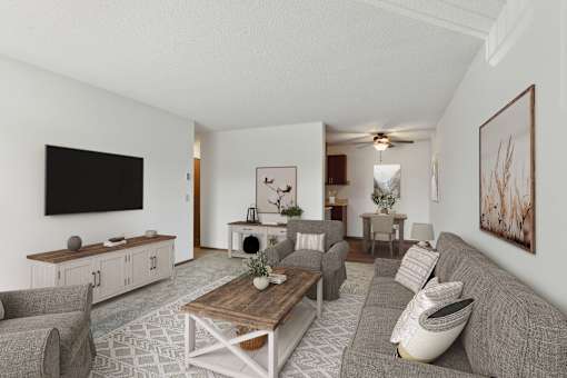 A living room with a grey couch, a wooden coffee table, and a flat screen TV mounted on the wall.