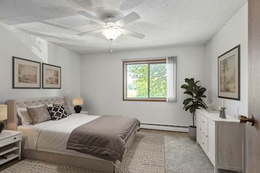 A bedroom with a bed, dresser, and ceiling fan.