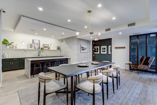 A modern dining room with a large table and chairs.