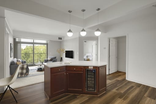 Kitchen island with wine cooler, a chair and livingroom at The Gables at Park Pointe, St. Louis Park, Minnesota