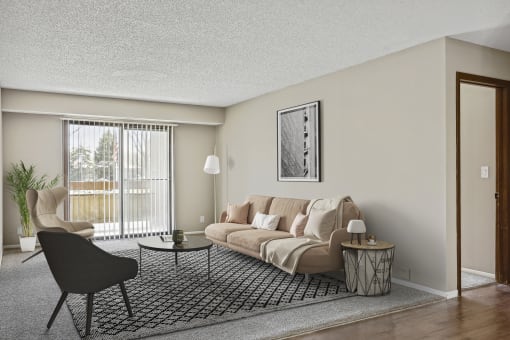 a living room with a beige couch and a black and white rug  at Willow Creek, Plymouth