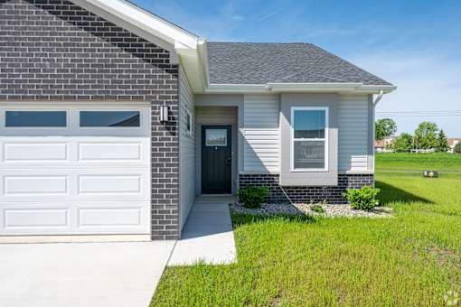 A house with a grey roof and a white garage door.at Concord Crossing, Indiana  