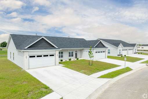 A white house with a grey roof and a driveway in front.at Concord Crossing, Lafayette Indiana  