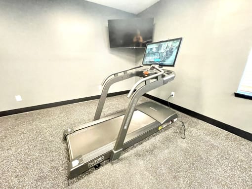 a treadmill in front of a flat screen tv at Murdock Gardens Apartments, Lafayette, IN 47904