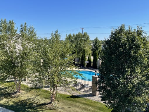 a backyard with a swimming pool and trees at Hawthorne Properties in Lafayette, IN 47905