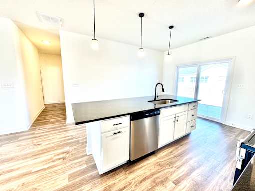 A kitchen with a black counter top and white cabinets.at Concord Crossing, Lafayette, IN  